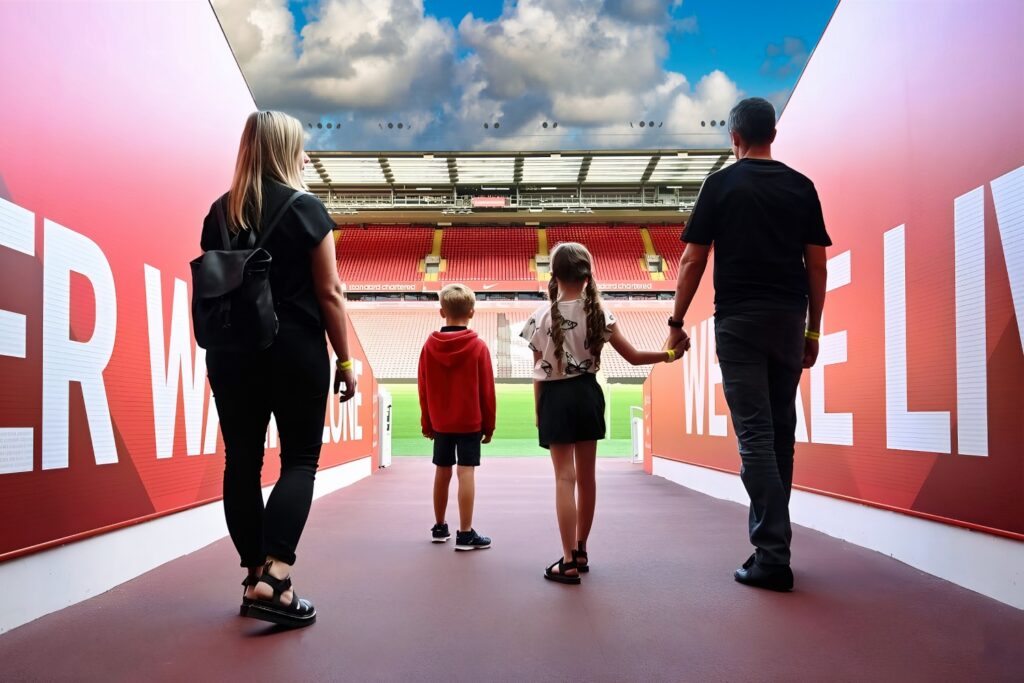 Anfield Stadium - Tunnel Family of four standing in the players tunnel at Anfield Stadium, looking out towards the pitch and Kop stand