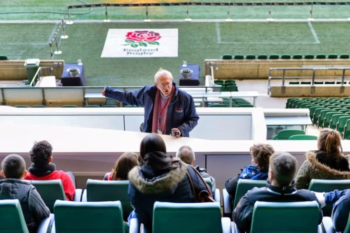 Stadium tour guide explaining to visitors in seating area